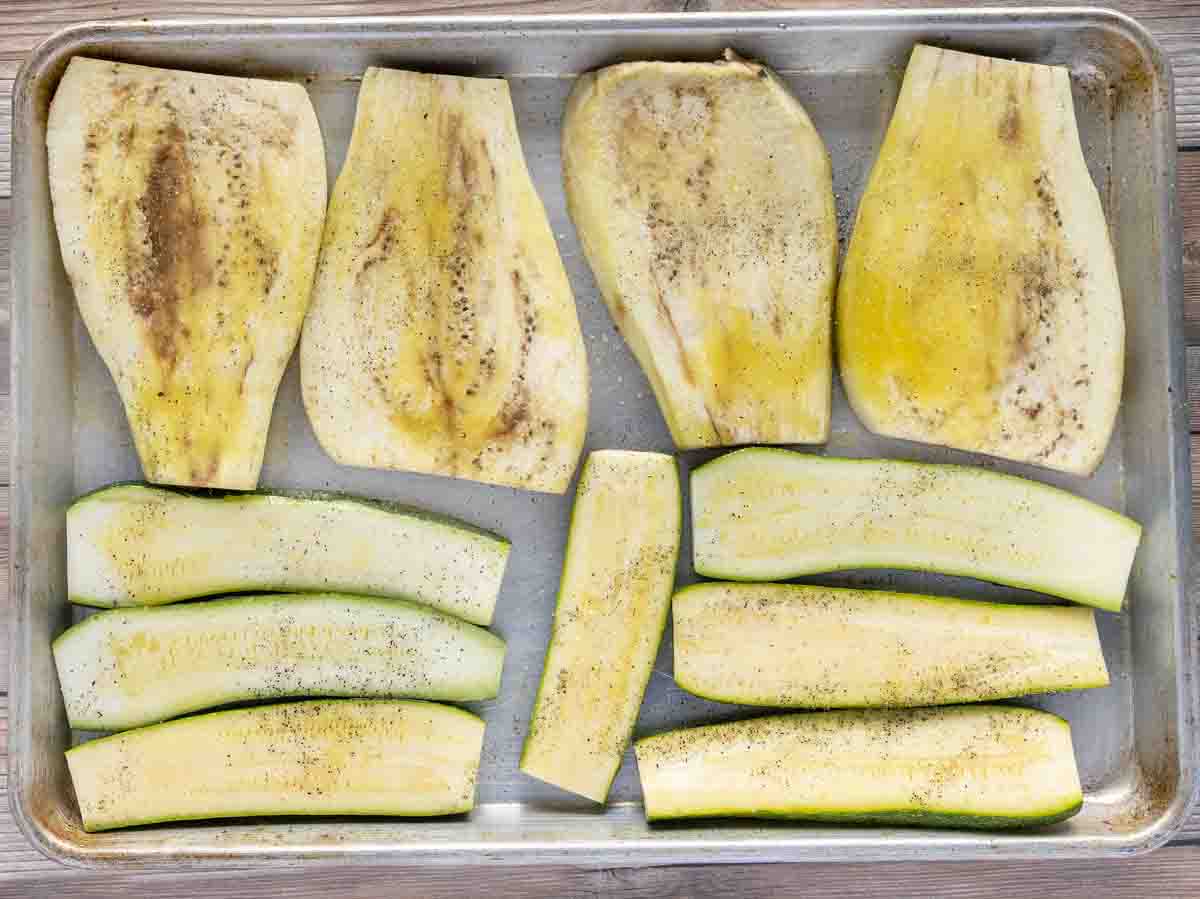 seasoned eggplant and zucchini planks on a sheet pan