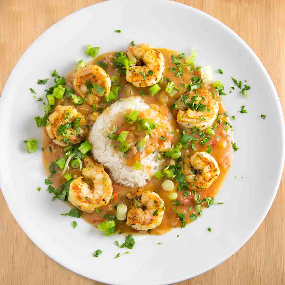 shrimp etouffee with rice on a white plate