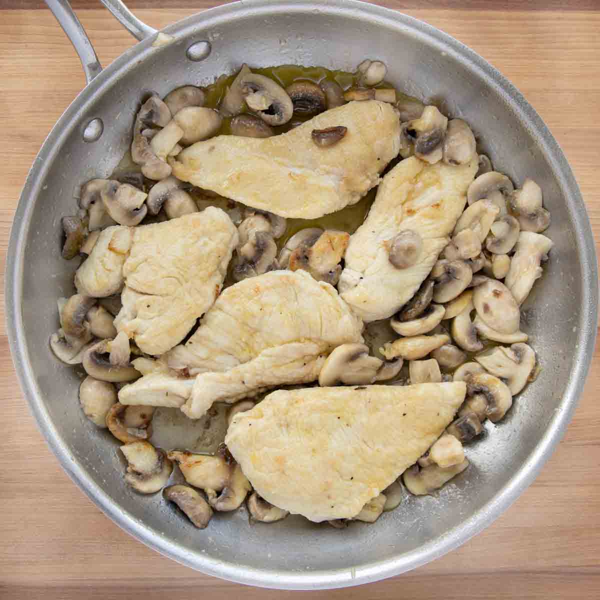 mushrooms and shallots sauteed with the chicken in a pan