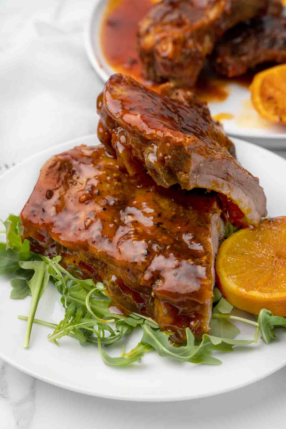 2 half racks of bbq sauced baby back ribs on white plate