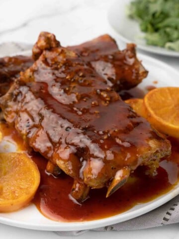 close up of slow cooker bbq ribs on white plate