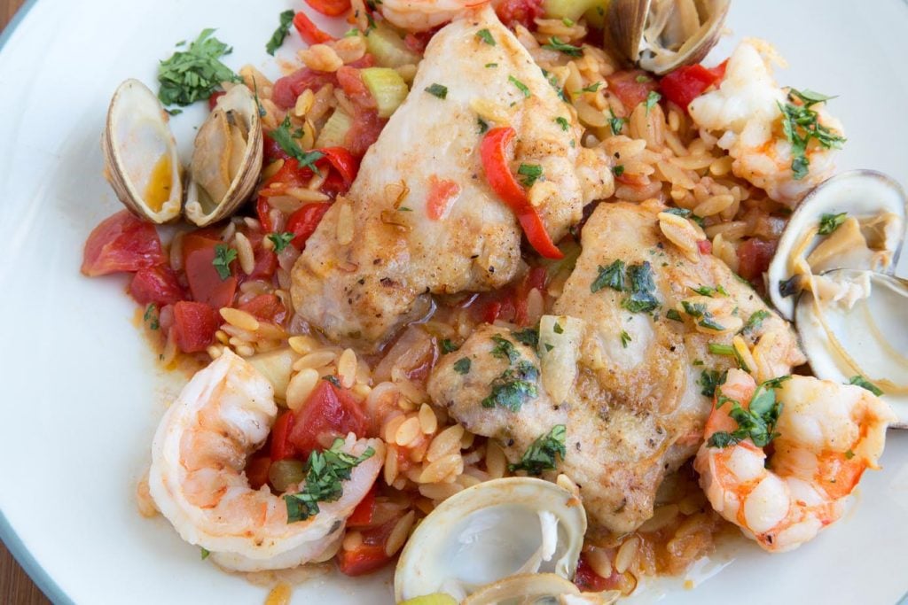 overhead shot of Chicken and Shrimp Orzo Paella on a white plate