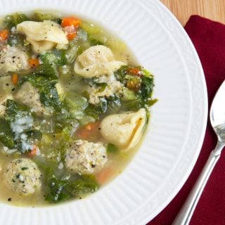 partial overhead view of a white bowl of Italian wedding soup