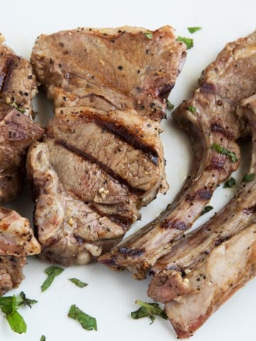overhead view of grilled lamb chops on a white platter