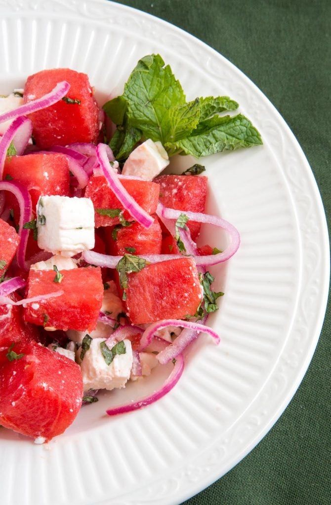 partial overhead shot of Watermelon feta salad with pickled onions in a white bowl