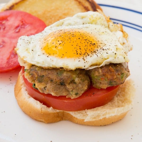 Veggie burger on a slice of tomato topped with a fried egg