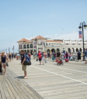 A group of people walking on the boardwalk in ocean city new jersey