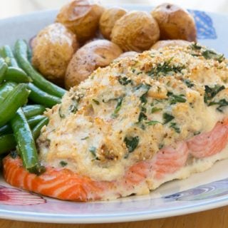 Salmon stuffed with crabmeat and cream cheese on a plate with green beans and baby potatoes