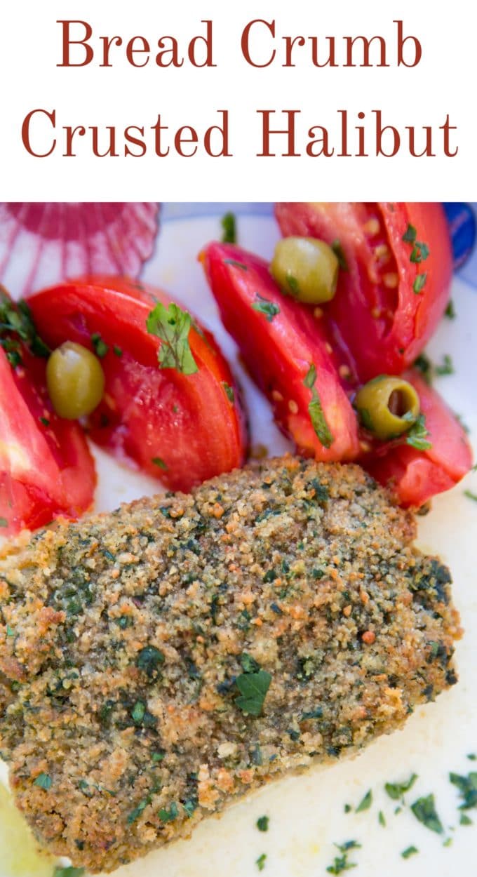 bread crumb crusted halibut and a tomato and olive salad on a white plate