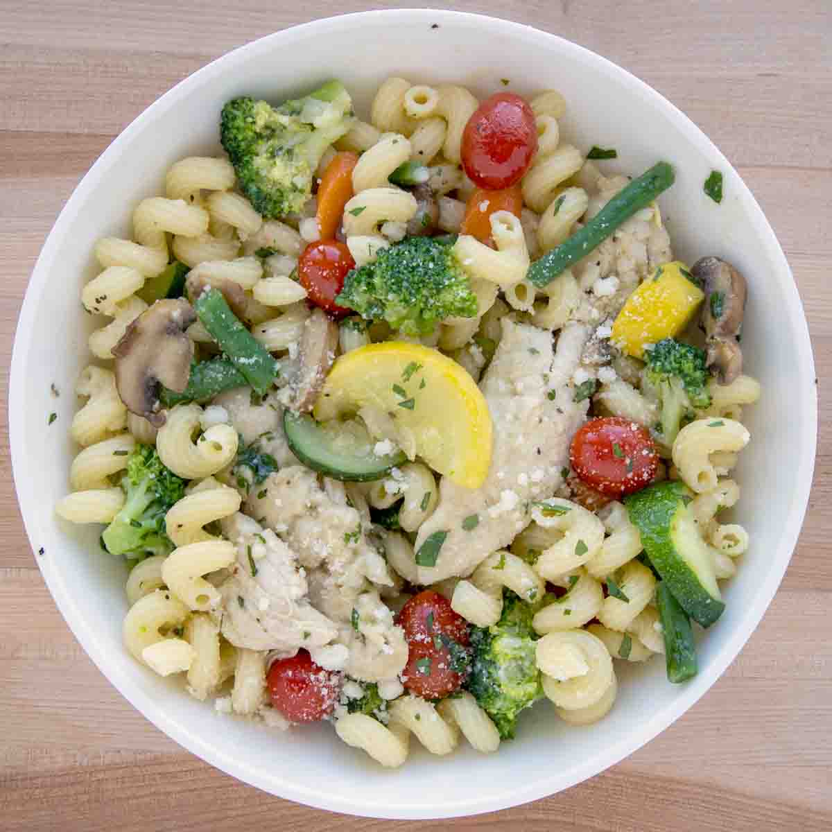 overhead viewe of chicken primavera in a white bowl