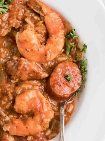 overhead partial view of Jambalaya in a white bowl with a spoon