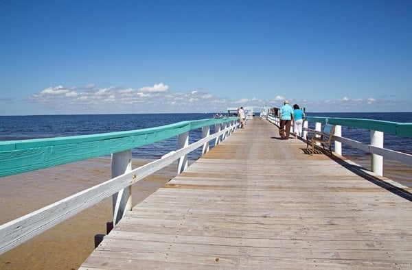 view down a long pier with blue skies