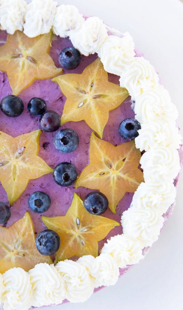 overhead partial view of a blueberry cream pie with star fruit slices and blueberries on top