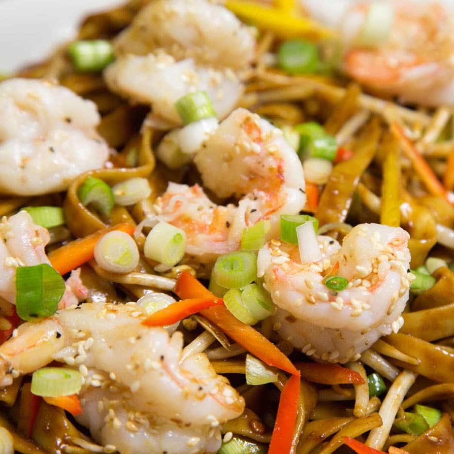 close up of Chinese style dan dan noodles with shrimp garnished with sliced scallions