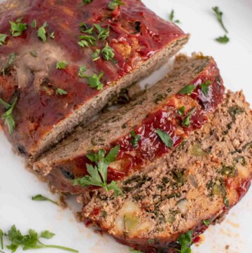 overhead view of sliced meatloaf on a white platter