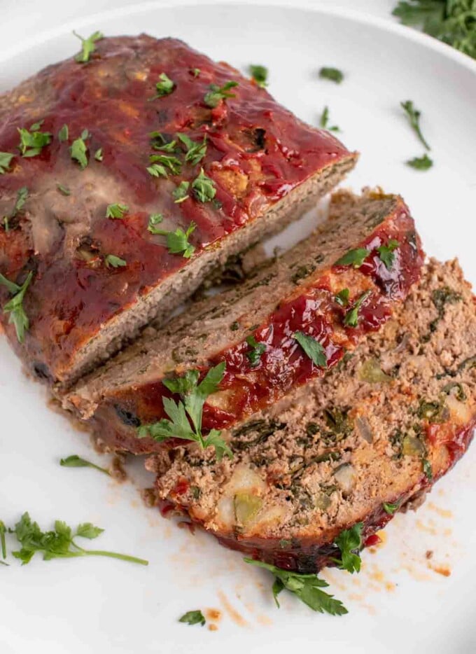 overhead view of sliced meatloaf on a white platter