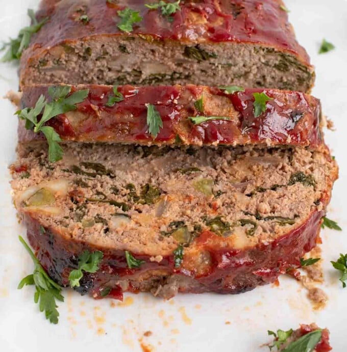 front view of sliced meatloaf on a white platter