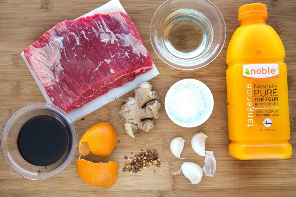 ingredients to make Tangerine Beef on a wooden cutting board