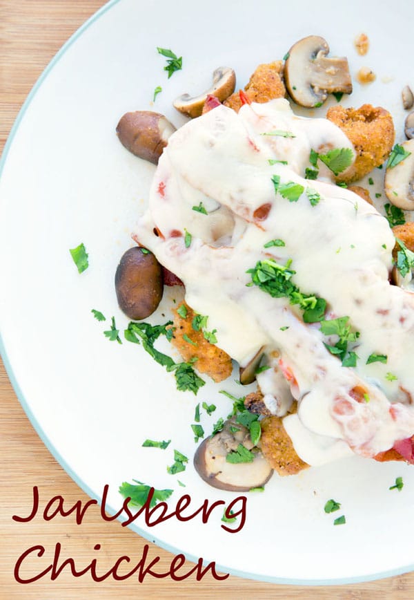 overhead partial view of Jarlsberg Chicken on a white plate with a green rim