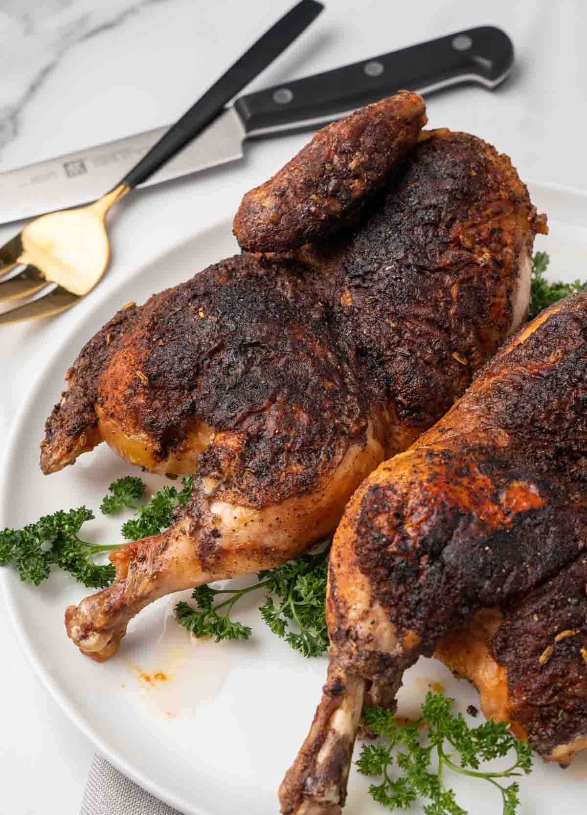 2 halves of blackened chicken on a white plate