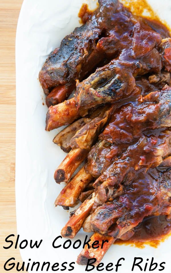 Slow cooker Guinness beef barbecue ribs on a white plate on top of a cutting board
