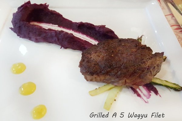 grilled filet of beef with a beet puree on a white plate