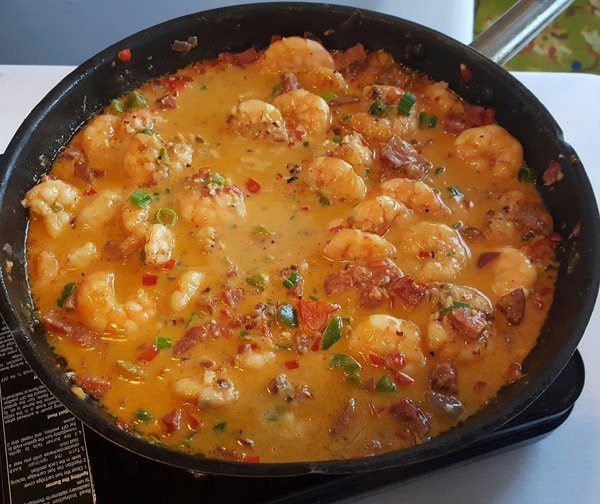 cast iron pan full of shrimp topping for shrimp and grits