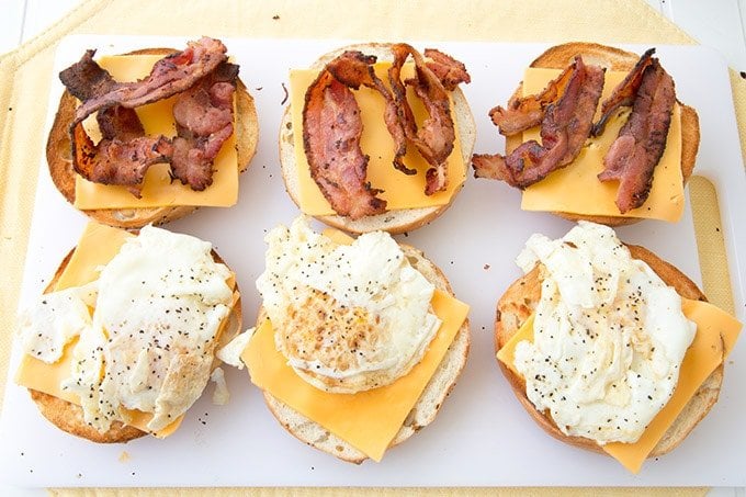 3 bagel sandwiches ovep with bacon and cheese on one side and friend egg and cheese on the other side