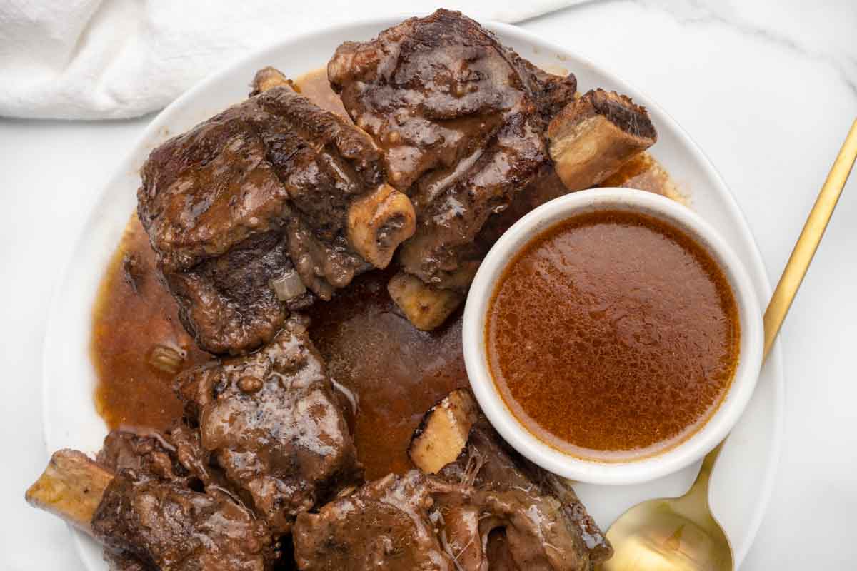 braised short ribs with gravy on a white platter