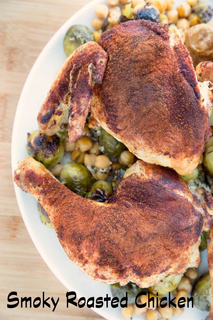 overhead view of Smoky Roasted Chicken quarters with Brussels Sprouts and Chic Peas on a white platter