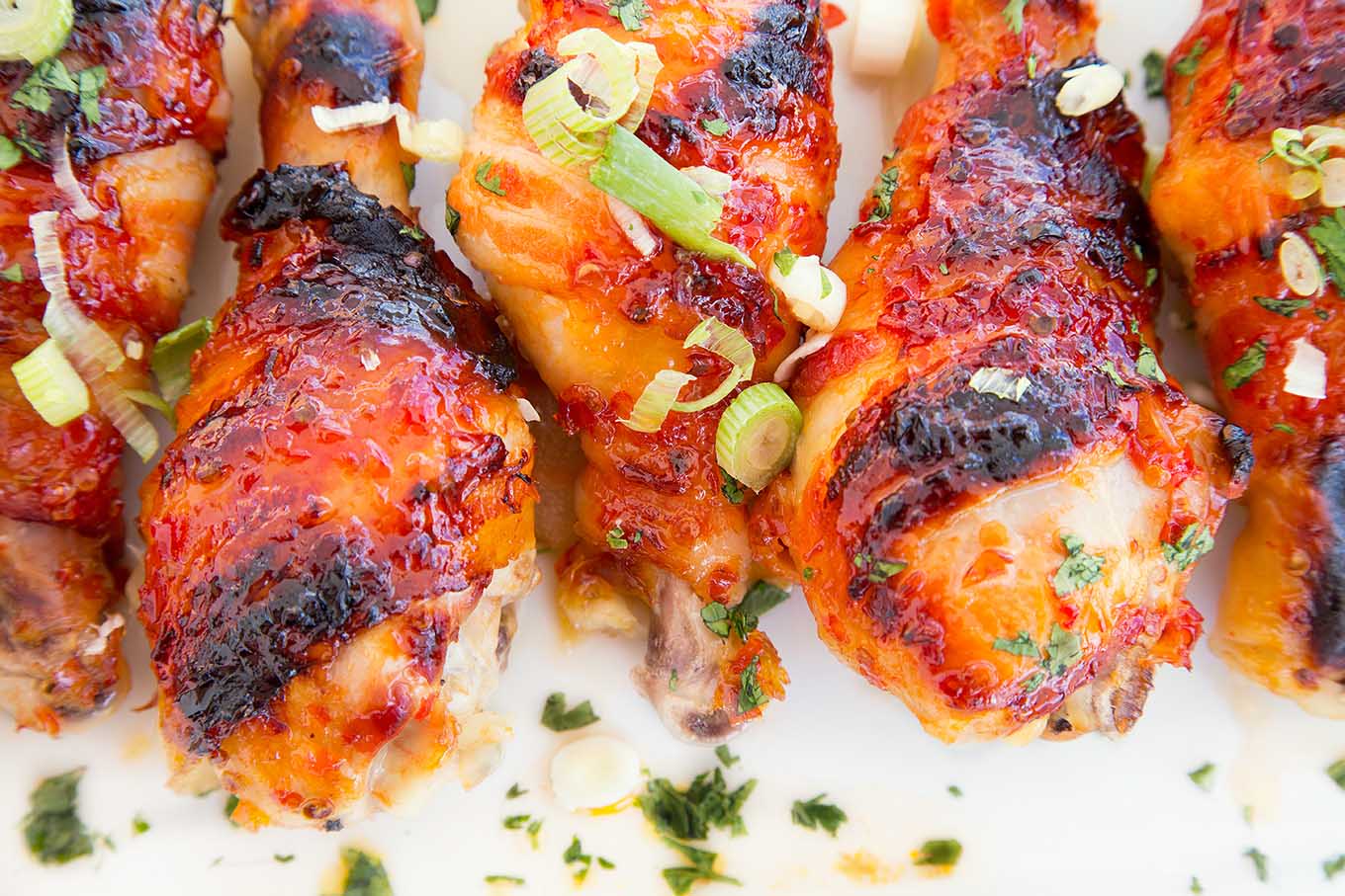 overhead view of cooked Asian Glazed Bacon Wrapped Chicken Legs on a white plate