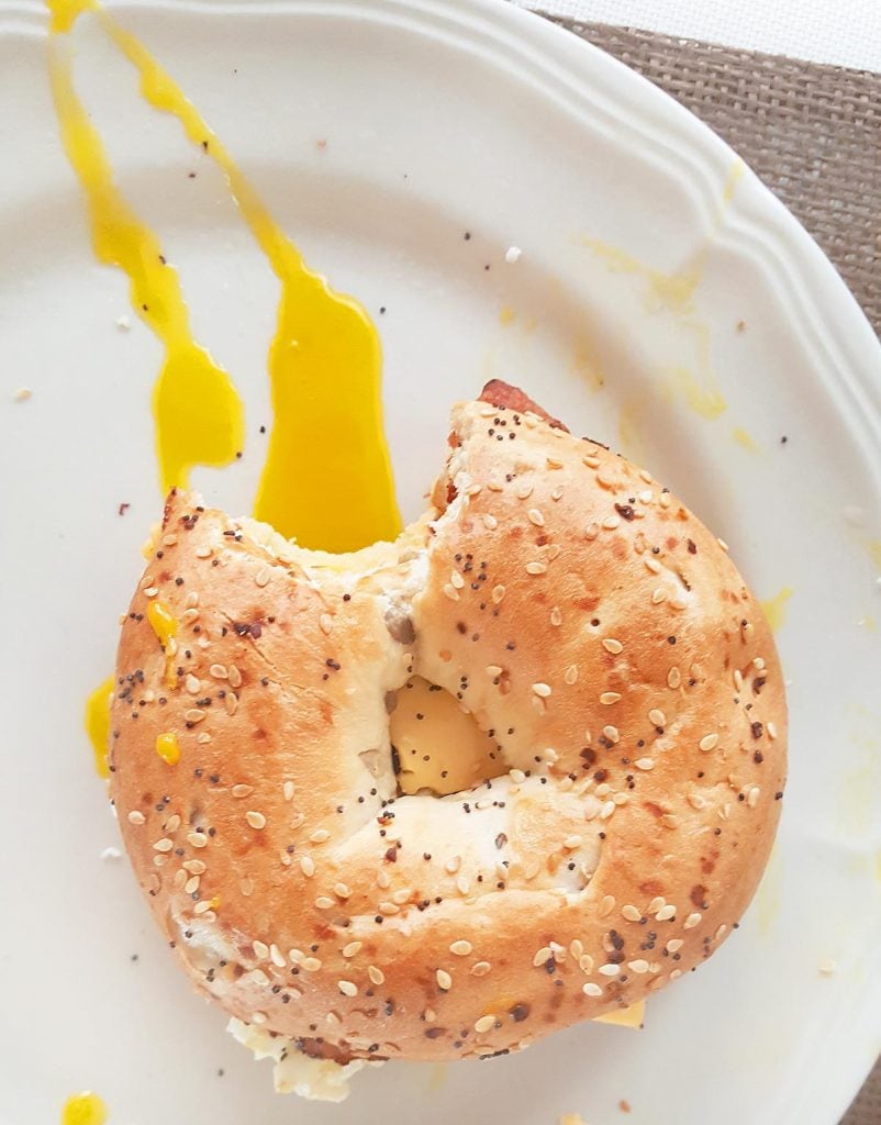 antime breakfast sandwich with egg yolk on a white plate