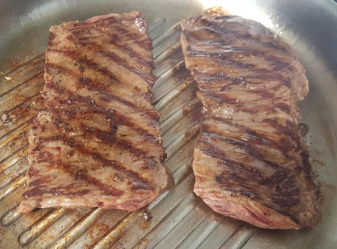 grill marked flank steak in a grill pan