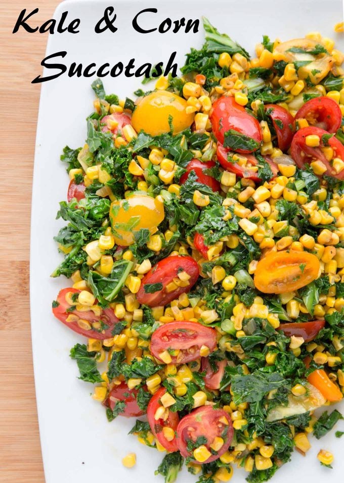 overhead shot of kale and corn succotash with grape tomatoes on a white platter