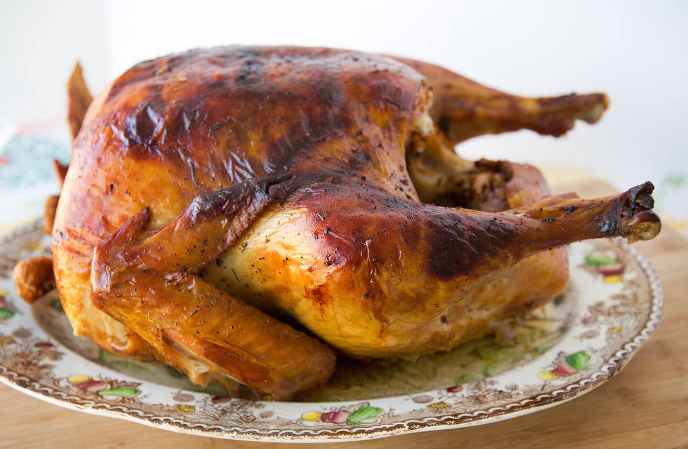 Young and matue men holding tray with homemade roasted turkey over