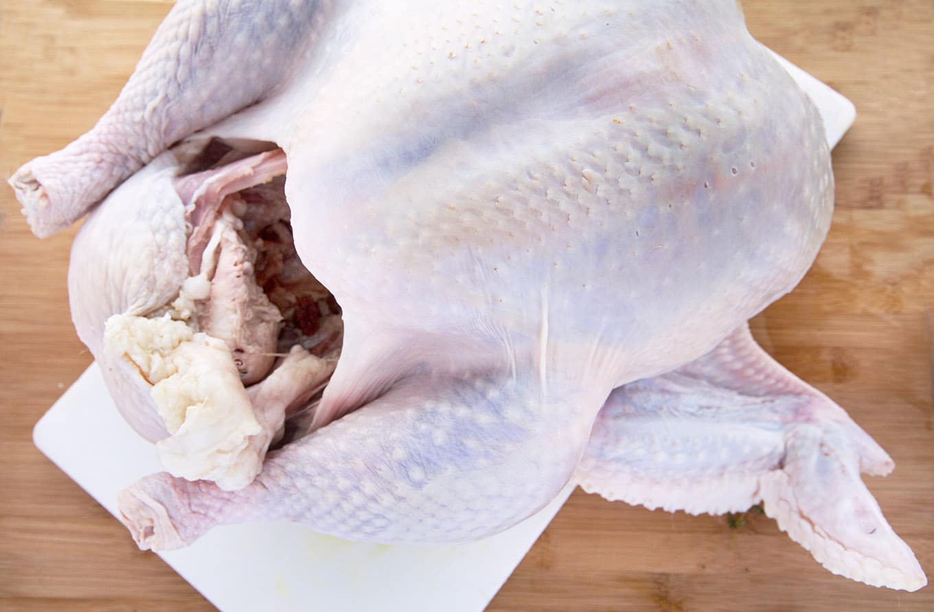 whole raw turkey on a cutting board