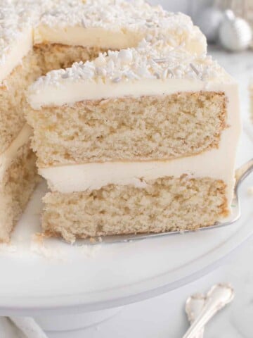 slice of white cake on a spatula being removed from the whole cake