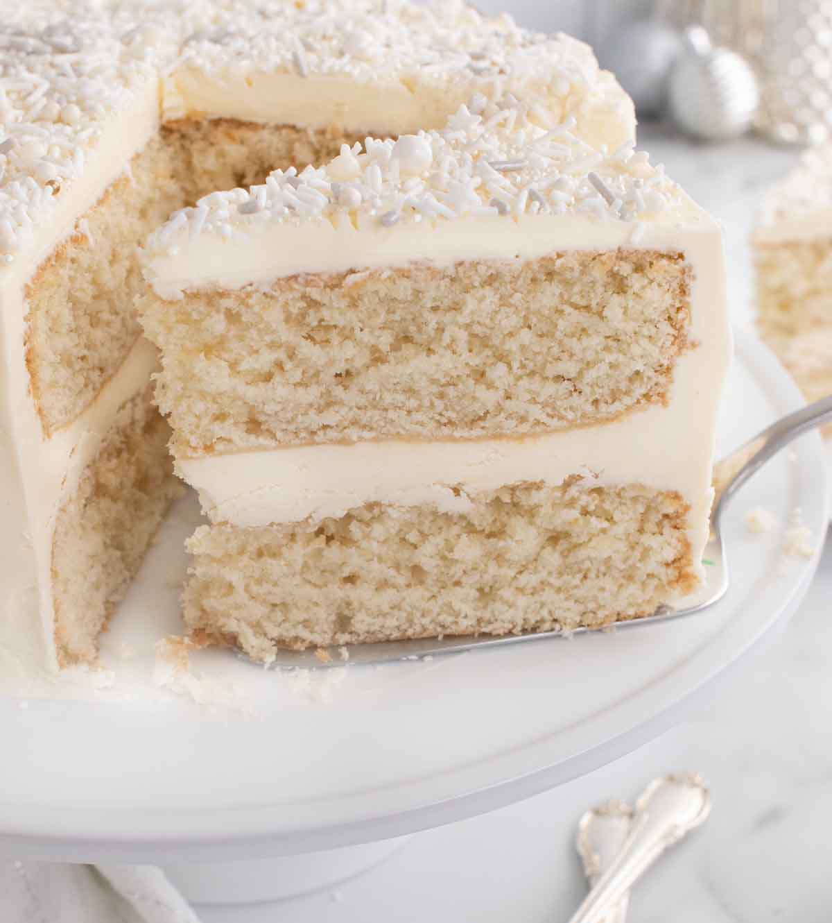 slice of white cake on a spatula being removed from the whole cake 