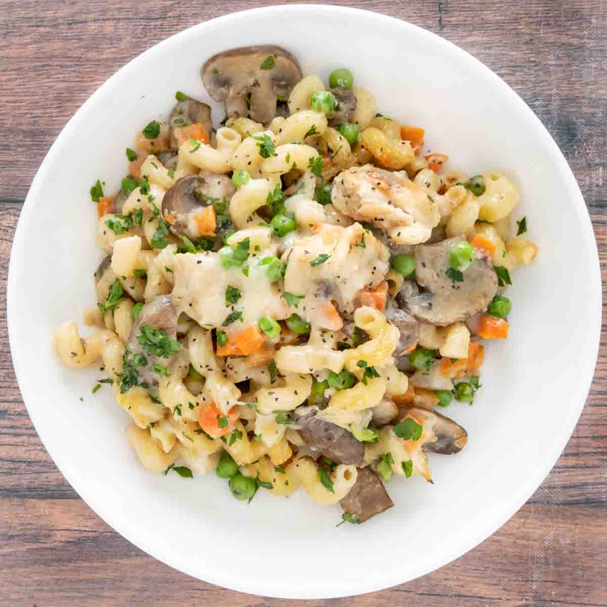Chicken and mushroom pasta bake in a white bowl.