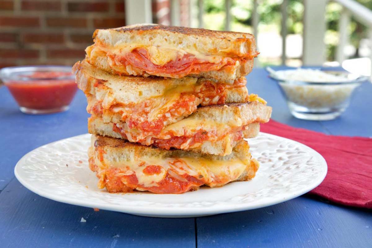 stack of Pepperoni Pizza grilled cheese sandwiches on a white plate
