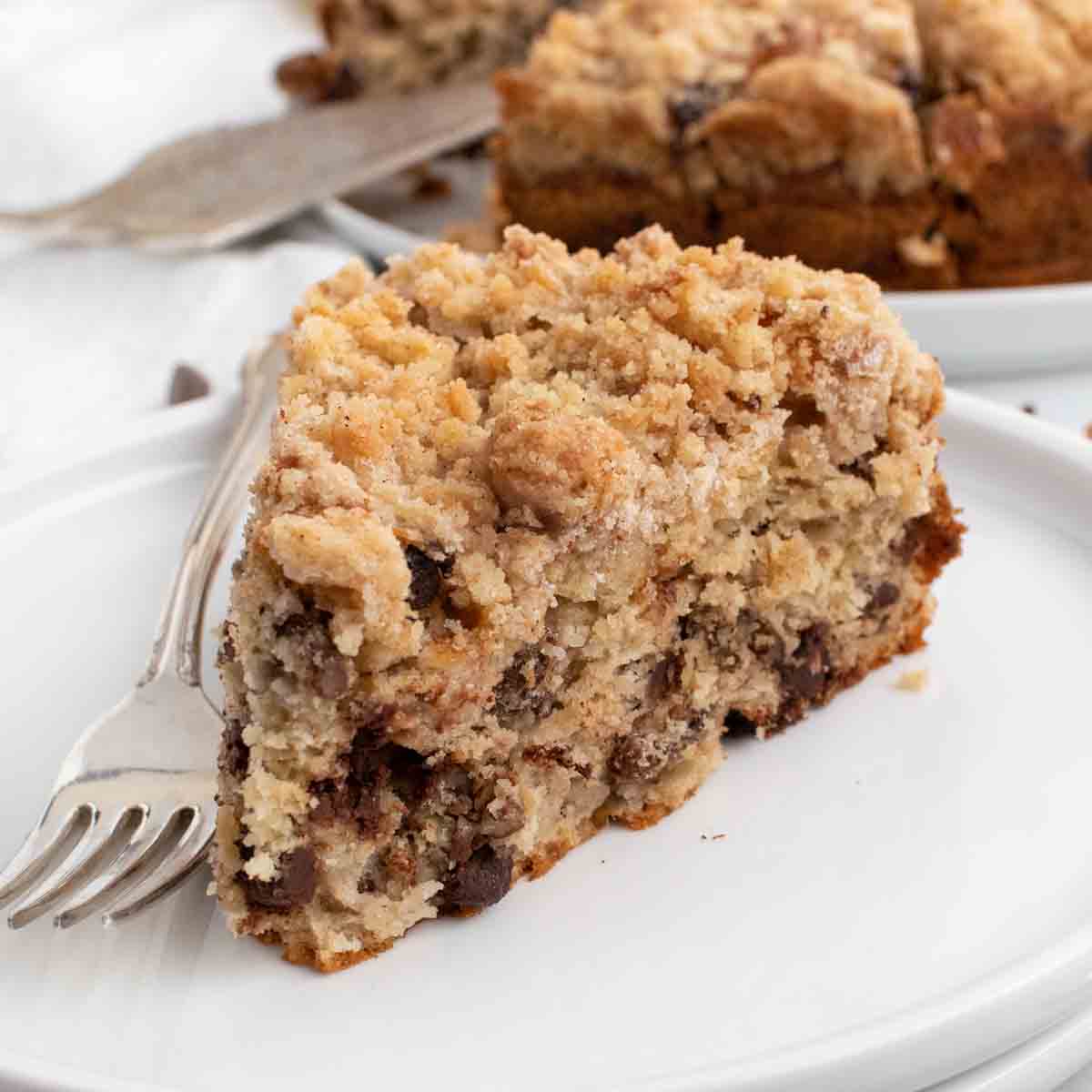 slice of banana crumb cake on a white plate with a fork