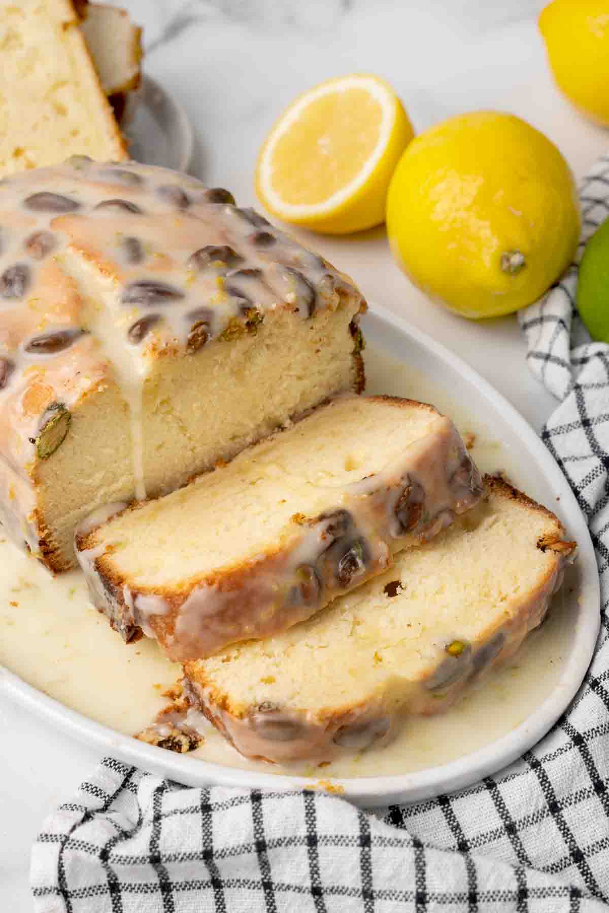 lemon pound cake sliced on a white platter with glaze