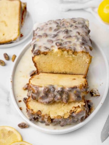 lemon pound cake sliced on a white platter with glaze