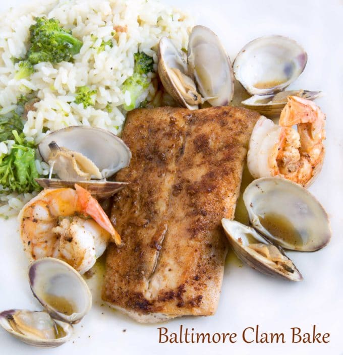 blackened fish, clams and shrimp on a white plate with rice and broccoli