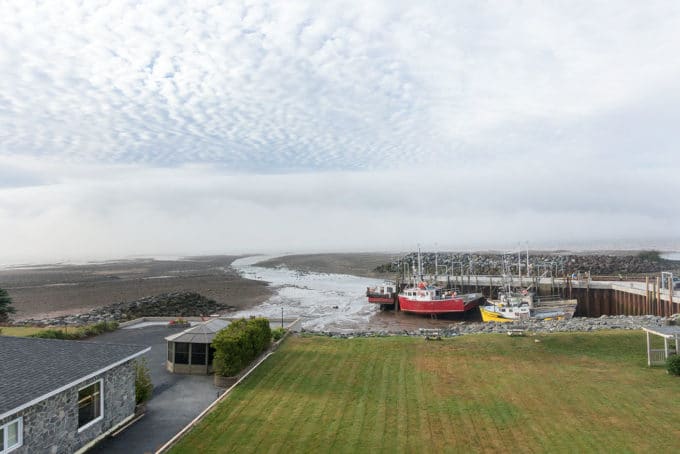 boats sitting on the ocean floor at a dock while the tides recede into the bay of fundy