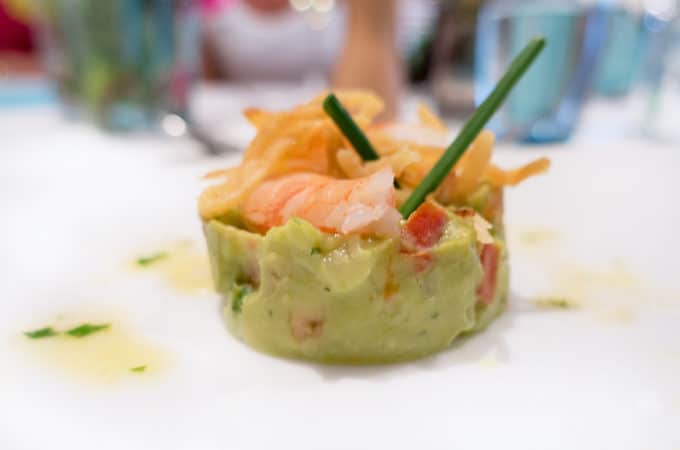 lime marinated poached shrimp in avocado tartare on a white plate