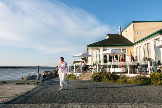 woman walking outside of a yellow building on the Mirimachi river in New Brunswick