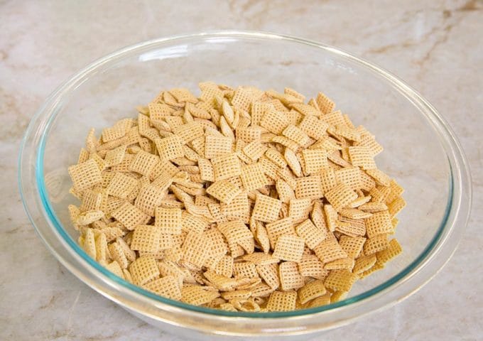 glass bowl with corn chex in it, sitting on a kitchen counter