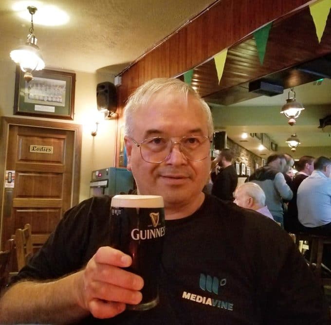 chef Dennis holding a pint of Guinness in a Killarney Pub