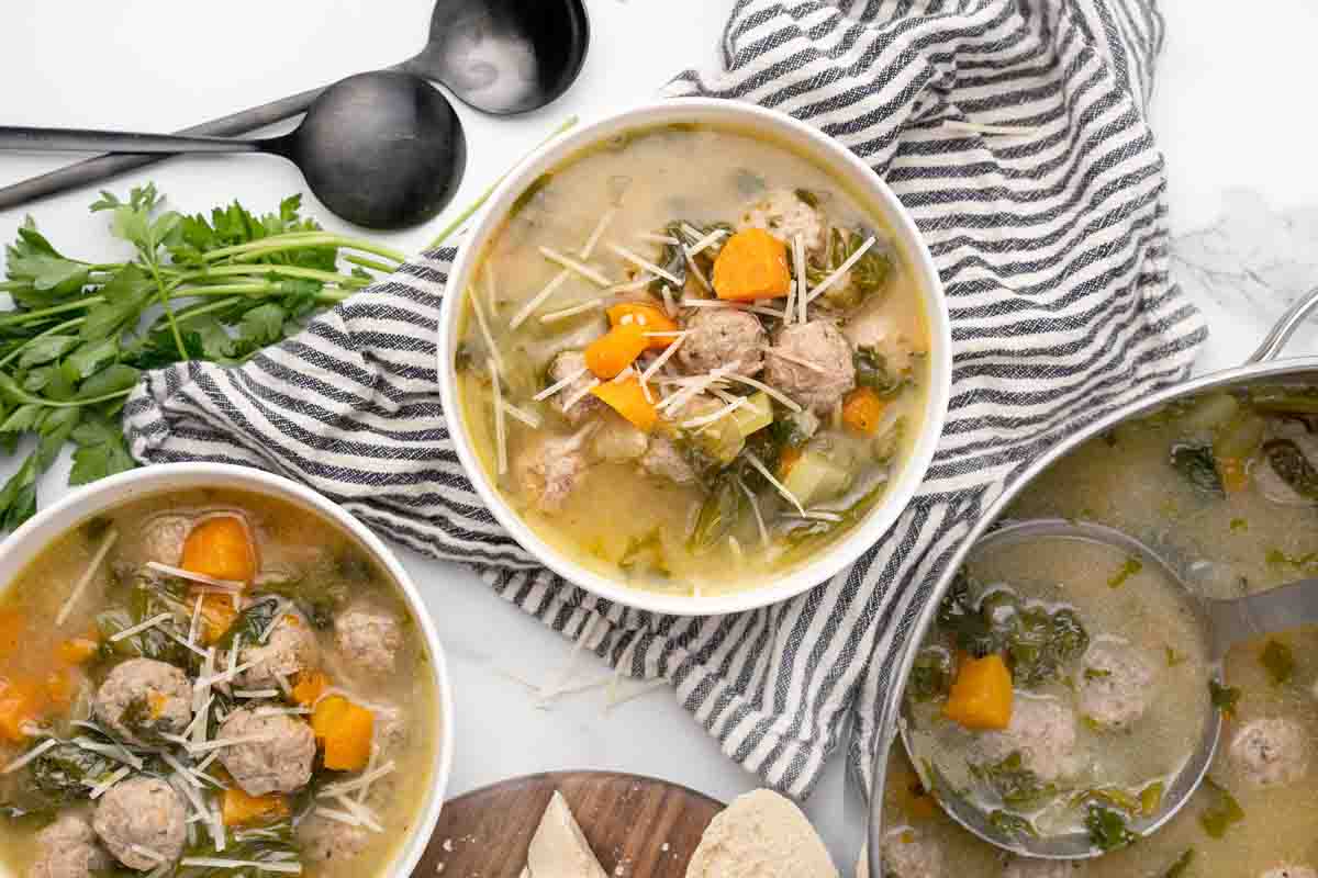 two bowls of wedding soup with pot of soup